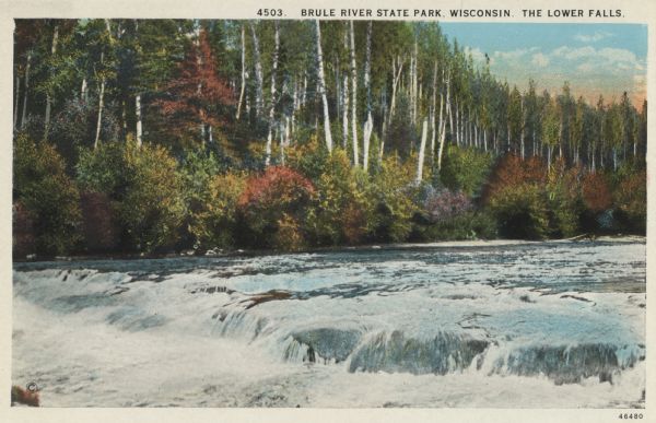 Colorized postcard view of the Lower Falls on the Brule River flowing through the forest. Some trees are showing autumn color. Caption reads: "Brule River State Park, Wisconsin. The Lower Falls."