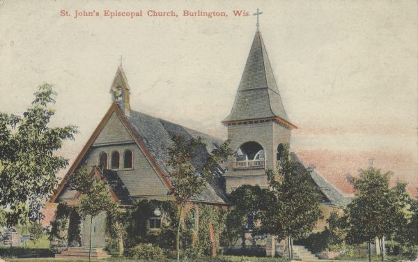 Colorized postcard of St. John's Episcopal Church, surrounded by many trees. Text at the top reads: "St. John's Episcopal Church, Burlington, Wis."