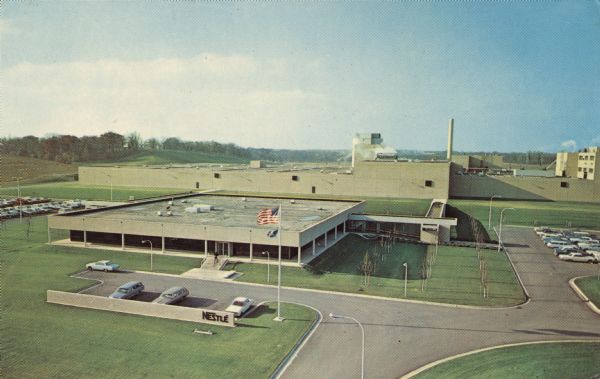 Color postcard of an elevated view of the Nestle Chocolate Factory. Text on back reads: "This ultramodern plant was opened in 1966 to supply Nestle Chocolate and cocoa customers in the Midwest. It stands on route 83 at the southern edge of Burlington. Visits by interested groups can be arranged by writing or calling in advance."