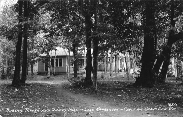 Photographic postcard view of the Bobynn Tavern and Dining Hall on Lake Namakagon. Lake Namakagon is located in the Chequamegon National Forest. Caption reads: "Bobynn Tavern and Dining Hall - Lake Namakagon - Cable and Grand View, Wis."