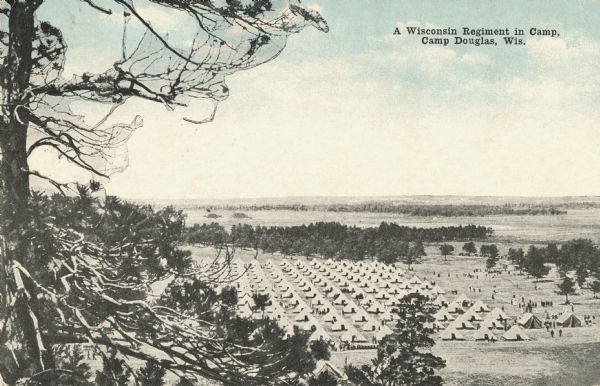 Colorized postcard of an elevated view through branches of a tree towards the camp of a Wisconsin Regiment. Tents are pitched in rows and trees are behind the camp. Soldiers are walking throughout the camp. Caption reads: "A Wisconsin Regiment in Camp, Camp Douglas, Wis."