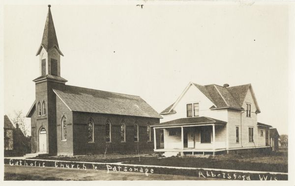 Exterior view of the Catholic church and parsonage. Caption reads: "Catholic Church and Parsonage, Abbotsford, Wis."