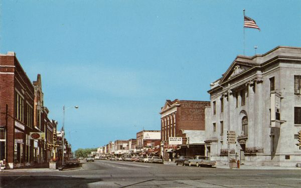 Color postcard of downtown Antigo, at the intersection of 5th Avenue and Superior Street looking east.