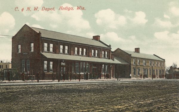Color view across street toward the Chicago and North Western Depot. Caption reads: "C. & N.W. Depot, Antigo, Wis."