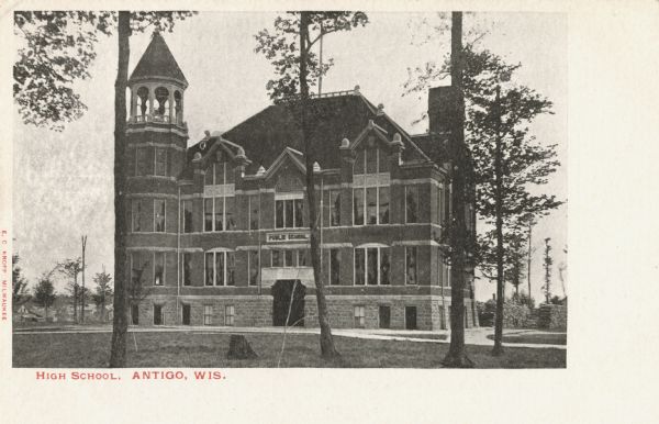 Postcard view of the main entrance to the public high school. Caption reads: "High School, Antigo, Wis."