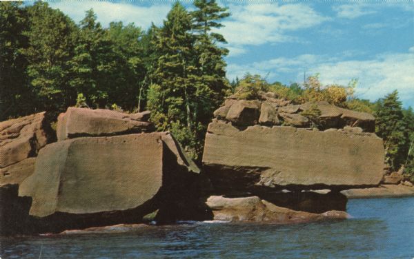 Photographic postcard of the rock formations on the shore of Stockton Island, one of the twenty-one islands comprising the Apostle Islands  in Lake Superior.
