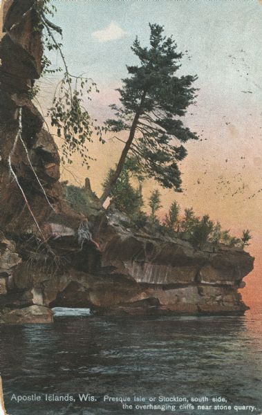 Postcard of the overhanging cliffs near the stone quarry on Presque Isle or Stockton Island's. Caption reads: "Apostle Islands, Wis. Presque Isle or Stockton, sought side, the overhanging cliffs near stone quarry."