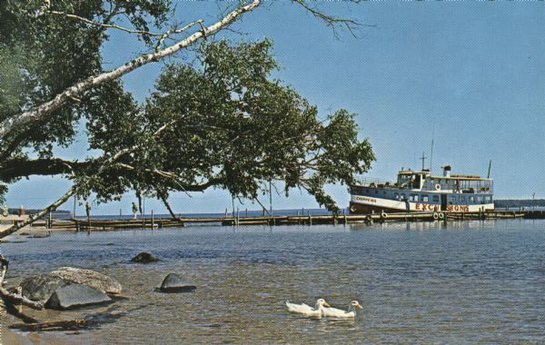 Postcard of the excursion boat the "Chippewa" docked in Bayfield, before taking passengers to the Apostle Islands. Two ducks can be seen swimming in the foreground.