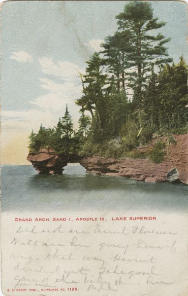 Colorized postcard of the Grand Arch geological formation on Sand Island, part of the Apostle Islands. Caption reads: "Grand Arch, Sand I., Apostle Is., Lake Superior."