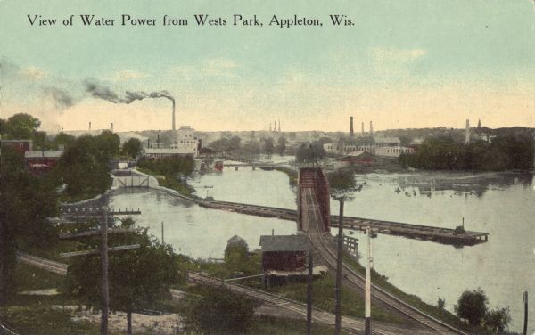 Elevated view of factories and railway line along the Fox River. Caption reads: "View of Water Power from Wests Park, Appleton, Wis."