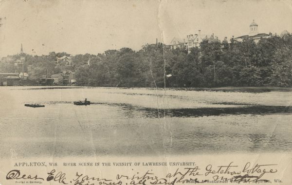 Photographic postcard of a scene of the Fox River near Lawrence University. The Main Building at Lawrence University can be seen in the background on the right. Caption reads: "Appleton, Wis. River Scene in the Vicinity of Lawrence University."