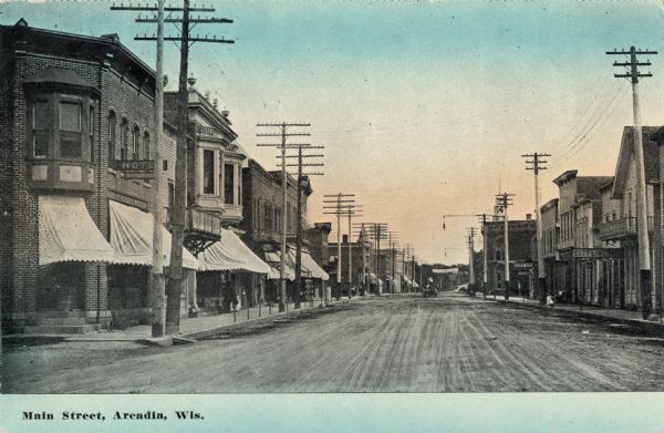 Color postcard of shops and businesses along Main Street. Caption reads: "Main Street, Arcadia, Wis."