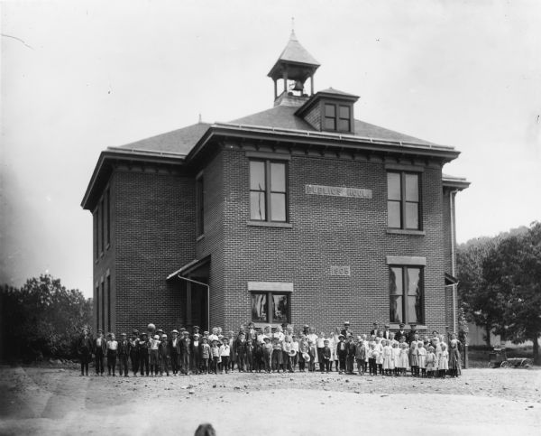 Students and teachers standing outside two-story brick Public School building.