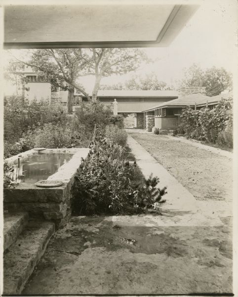 Taliesin I courtyard from the porte-cochere looking toward the stable wing. The statue, "Flower in a Crannied Wall," is in the center with the small decorative pond in the foreground.