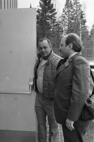 Project ELF activist Jerry Holter (left) and John Lavine, head of the Lavine Newspaper Groups based in Chippewa Falls, outside the Clam Lake facilities of Project ELF.