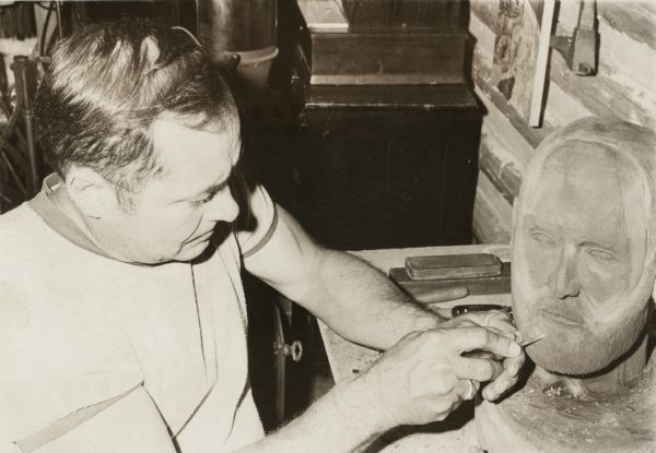 Clam Lake artist Jerry Holter carving a wooden portrait of John A. Lavine, a Wisconsin newspaper publisher.