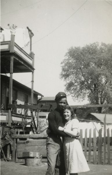 Lewis Arms embraces his neighbor Helen Berry behind the house at 629 Milton Street.