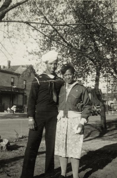 Lewis Arms poses outdoors with his mother Mamie (Arms) Hall. He is wearing his Navy uniform.