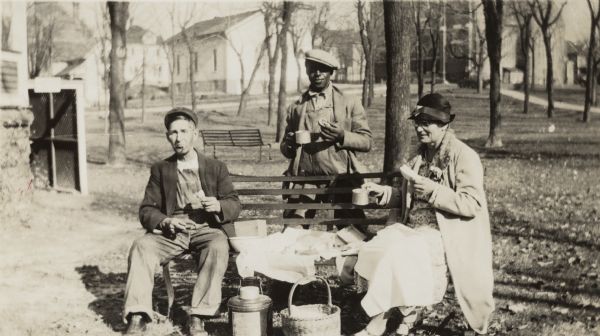 Bernard Arms (standing), uncle of Lewis Arms, shares a picnic with his neighbors Mr. and Mrs. (Betsy) Nofsinger.