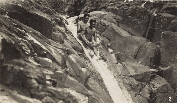 Two men slide down a waterfall in Hawaii. One of them is Fred Niendorf, a friend of Lewis Arms.
