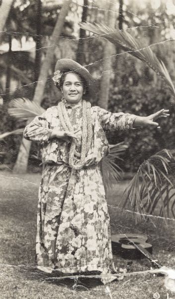 Candid portrait of Hilo Hattie (born Clarissa "Clara" Haili), who was a Hawaiian musician, dancer, actress and comedian. There is a guitar on the ground next to her.