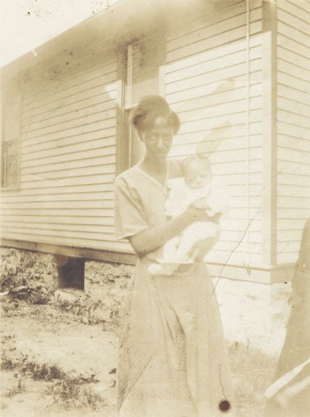 Mamie Arms holds her infant son Lewis Arms. On the back is an inscription to "Ona x Walter".