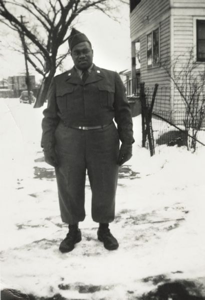 Chester Elvord, cousin of Louis (Lew) Arms, poses outdoors on Lake Street wearing his military uniform.