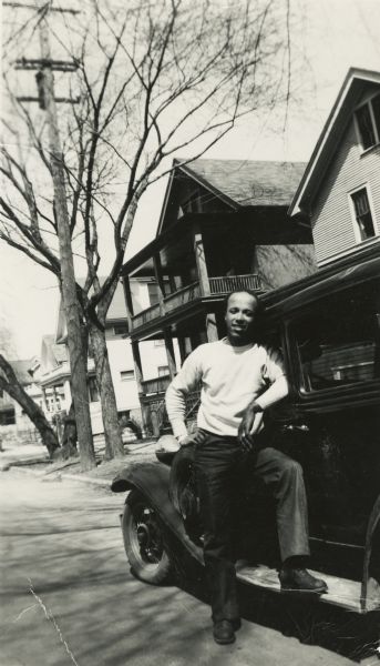 Lewis Arms poses next to his 1932 Chrysler automobile, probably on Milton Street.
