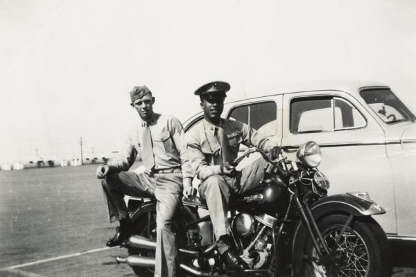 Lewis Arms (right) and another Marine pose on a motorcycle near an automobile at Camp Pendleton.