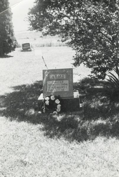 Walter and Ionie Arms's grave marker in the shade of a tall bush at the Burr Ridge cemetery.