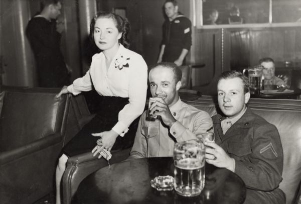 Lewis Arms (left) and his friend Norbert Pfife ("a kid from . . . around Milwaukee") enjoy a pitcher of beer at Bradley's Bar in downtown San Diego. Beside them is their cocktail waitress Virginia.