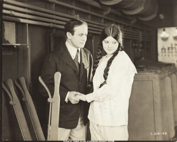 Escape artist Harry Houdini with co-star Lila Lee in the silent film, "Terror Island," a Paramount release. The climax consists of Houdini saving Lee from a safe which is being lowered into the sea.