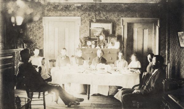 Mary Meade Grignon (Mrs. Charles) surrounded by her family at the Grignon House in Kaukauna. Mrs. Grignon is in the center and Ross Grignon is thought to be the man on the right.