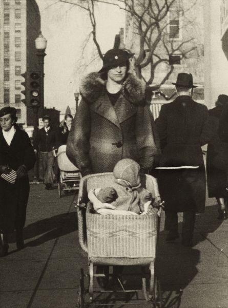 Mrs. Alvina Bergor walking on the Capitol Square with her daughter Monona in a baby carriage.