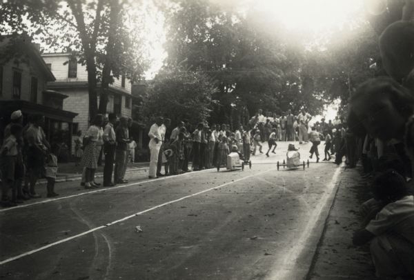 Paul Johnson (left) and James Borden (right) racing down Gorham Street at Madison's (Wisconsin) 1940 soap box derby. They have just left the starting ramp. Thirteen year-old James beat twelve year-old Paul.  James went on to compete at the national race, the All-American Soap Box Derby in Akron, Ohio, the next month.