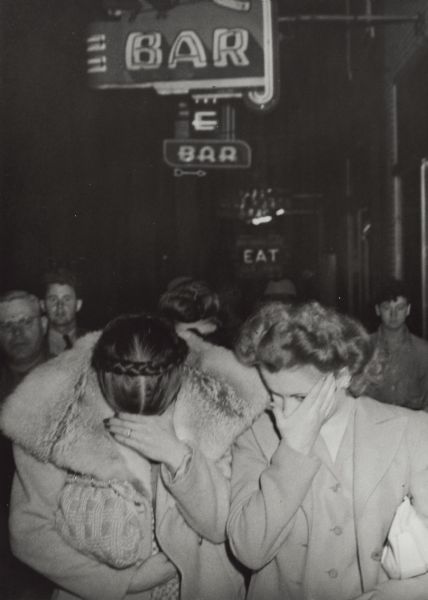 Three women hide their faces as they walk in front of State Agents after exiting their place of business during a sweeping raid on many Hurley area establishments. The arrest warrants were for gambling and prostitution.
