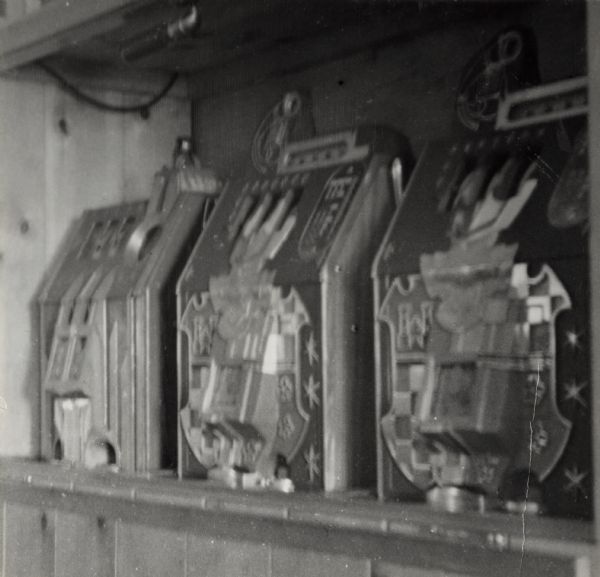 Three illegal gambling machines in the Green Parrot Tavern on Highway 12, north of Elkhorn. The machines are in a case, which the proprietor closes when he becomes suspicious of strangers.