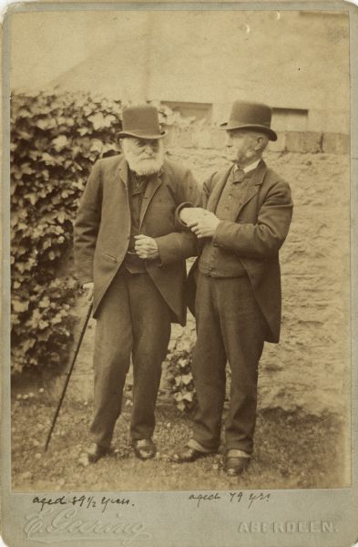 Outdoor photograph near Aberdeenshire, Scotland of probably George Johnston (1803-1893), 89-1/2-years-old, and an unknown man, possibly a brother-in-law, 79-years-old. They are standing arm in arm, wearing suits and top hats.

George was the father of John Johnston (1836-1904), a Milwaukee banker, and brother-in-law of Alexander Mitchell, also a Milwaukee banker. He was the grandfather of John Thorsen Johnston (1884-1939).