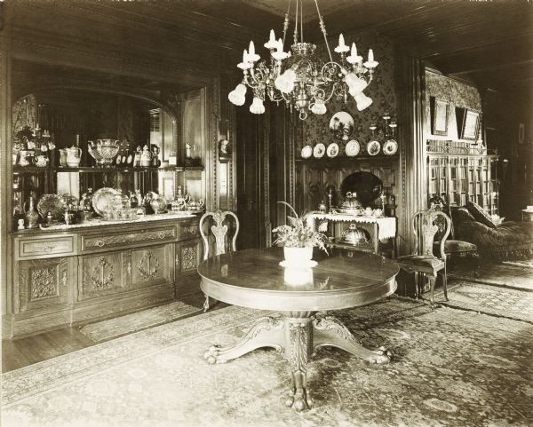 Dining room in the home of John Johnston (1836-1904), a successful Milwaukee banker, located at 645 Franklin Place, also known as "The Lion House." The library can be seen through a large doorway in the background.

The home was built in 1851 for Edward Diedrichs. Johnston purchased it from its third owner in 1896.