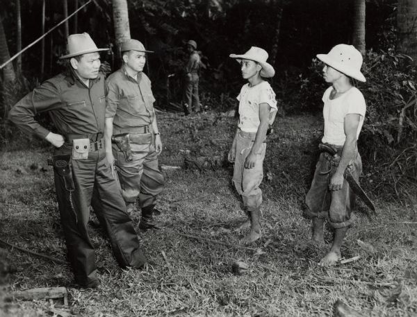 Ramon Magsaysay (in the wide-brimmed hat), then secretary of defense and later the President of the Philippines, during the campaign against the communist Huks. The two civilians are suspected Huk guerrillas.