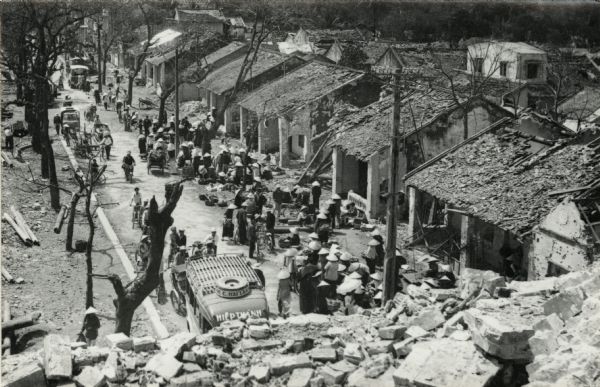 Elevated view of refugees after the Tet Offensive, camped out front of their damaged homes. Although not identified, it is believed the image is a street scene in Hue. It was witnessed by American journalist Robert Shaplen shortly after the South Vietnamese retook control of the city.