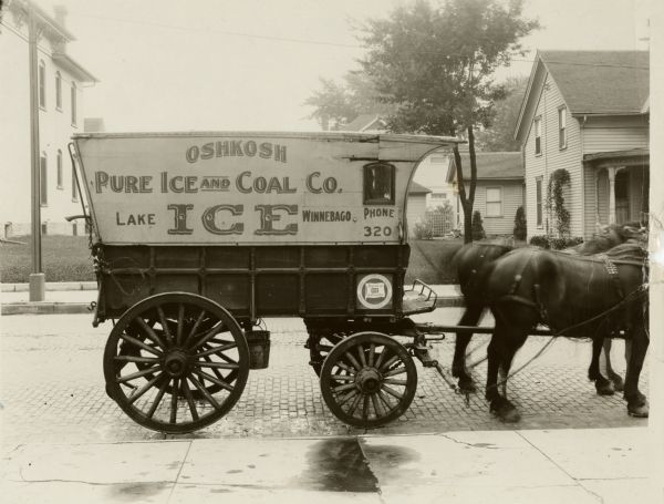 Oshkosh Pure Ice and Coal Co. horse-drawn wagon. Note on back: #3, camera pointing west and set 23 feet east of east curb, east wheel of wagon was 3 feet west of curb.