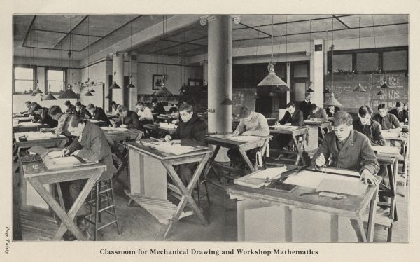 Students are seated at desks in a mechanical drawing and workshop mathematics class at the Milwaukee School of Trades.