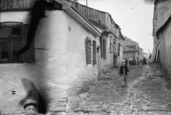 A street scene in the Jewish ghetto in Szydlowiec, Poland. In his scrapbook, journalist Alvin Steinkopf, who took the picture, noted that conditions were filthy.