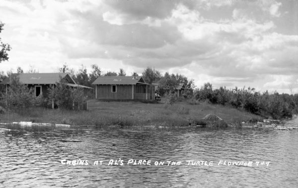 Modest cabins located along shoreline of Turtle Flowage on a cloudy day.