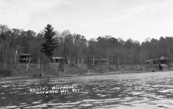 View from water of cabins in woods near shore of northern Wisconsin lake.