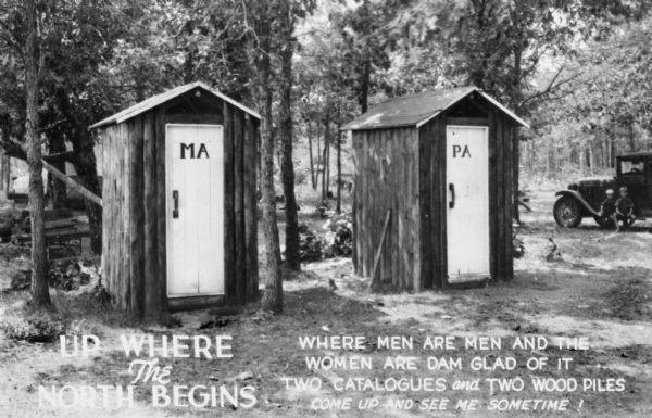 Two outhouses in the woods made of vertical logs. On their doors, one says "PA" and the other says "MA". There is an automobile with two small boys sitting on the running board on the far right. At the bottom of the image is printed "WHERE MEN ARE MEN AND THE WOMEN ARE DAM GLAD OF IT, TWO CATALOGUES and TWO WOOD PILES, COME UP AND SEE ME SOMETIME!"