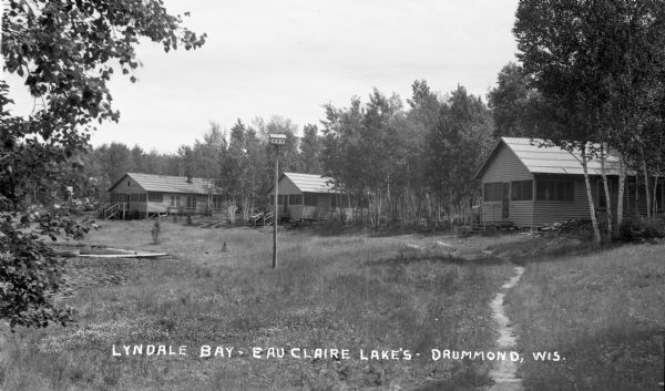 Cabins around clearing in the woods at Lyndale Bay Resort on Upper Eau Claire Lake.