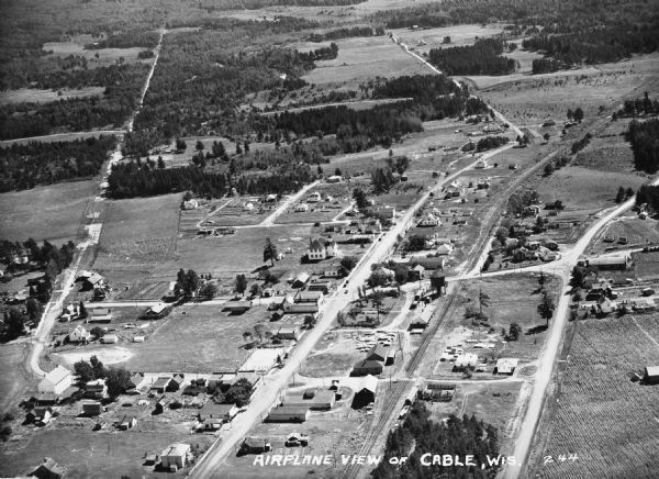 Aerial view of Cable, in northern Wisconsin. Text at foot reads: "Airplane View of Cable, Wis. 244."