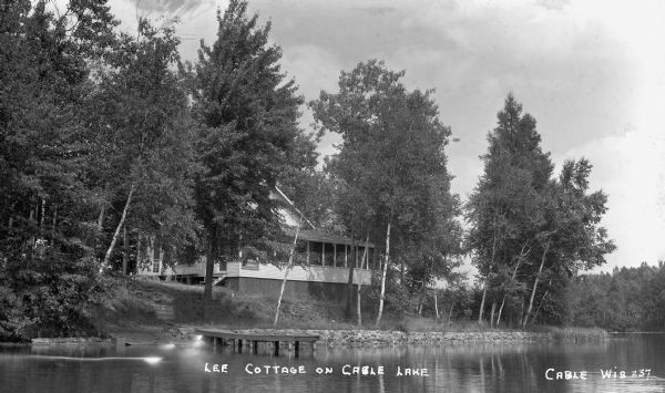 View from water of a two-story cottage on shore of Cable Lake.